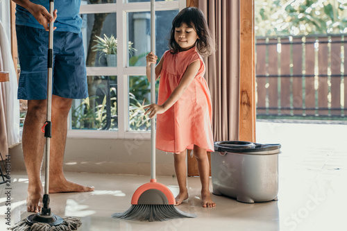 father and daughter clean up the house together sweep the floor