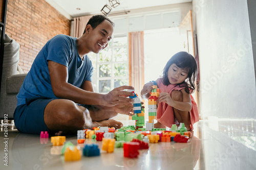 father and daughter playing puzzle making creative toy
