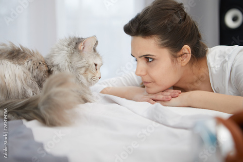 Happy Young Woman With Cat In Bed At Home