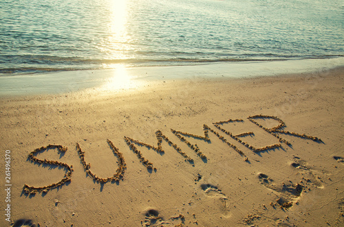 Word summer written on white sand beach. Summer holiday, travel and vacation concept. Abstract sea beach background