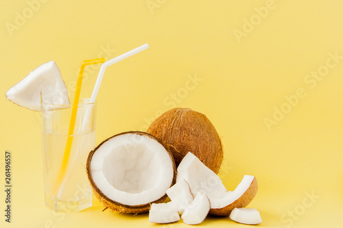 Fresh Coconut cocktail with a straws on yellow background