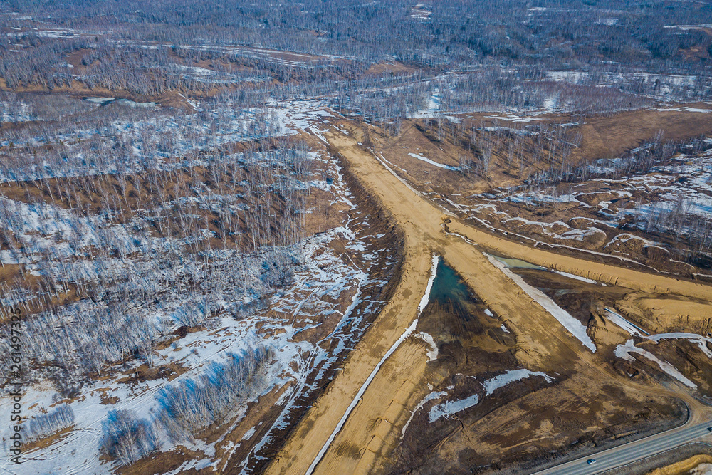 Aerial drone top view photo of track road in the industrial area with construction sites in the springtime with unmelted ice Aerial drone top view photo of track road in the industrial area with construction sites in the springtime with unmelted ice
