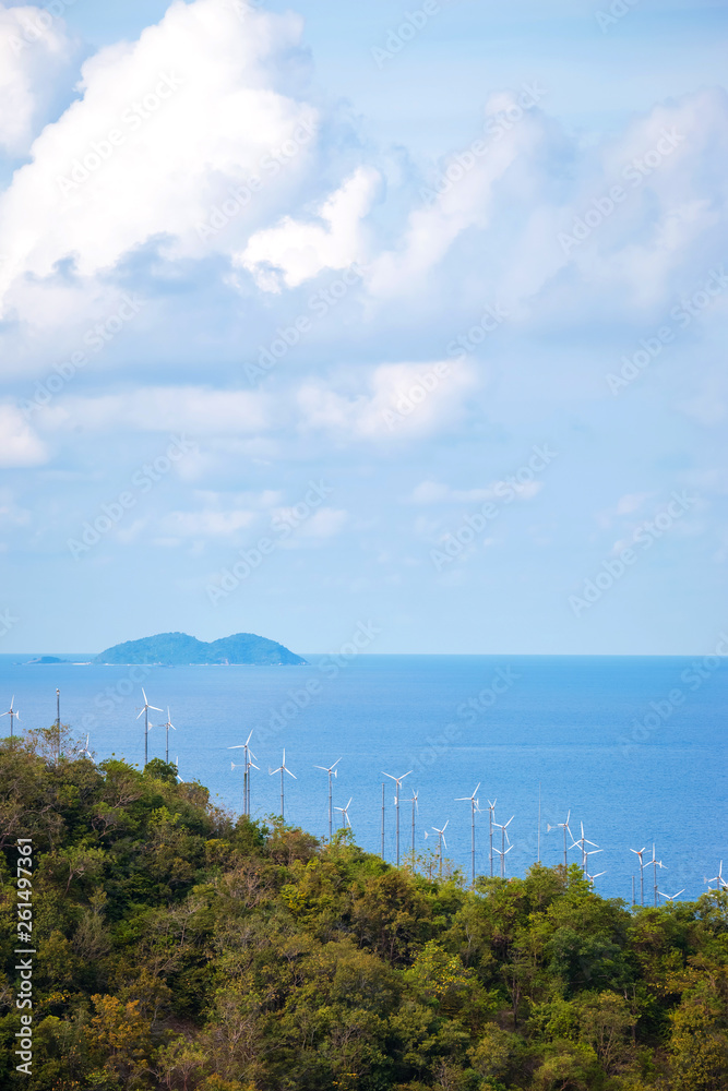 wind turbine generating electricity on mountain near sea.