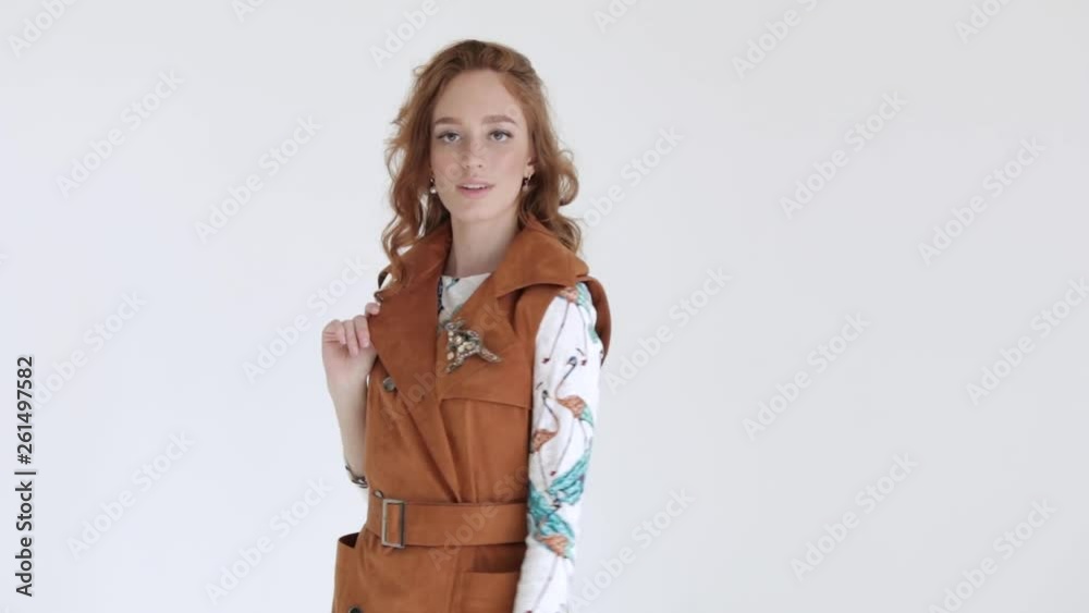 Professional model, girl with red hair in coat posing on white background, slow mo Professional model, girl with red hair in coat posing on white background, slow mo