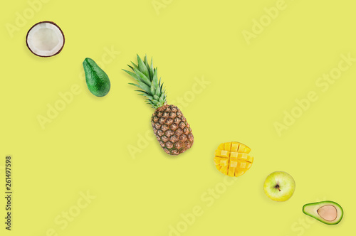 Row of different fresh ripe exotical fruits scattered on yellow table on kitchen or market. Top view. Diet concept. Copy space photo