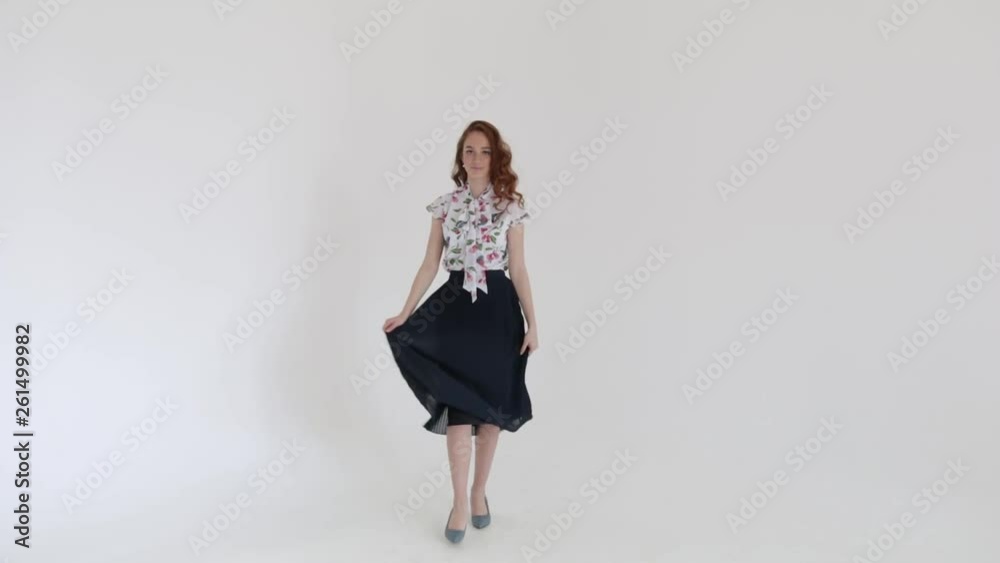 Attractive girl dancing and spinning with blue dress. Cute brunette smiling and having fun on white background, slow mo Attractive girl dancing and spinning with blue dress. Cute brunette smiling and having fun on white background, slow mo