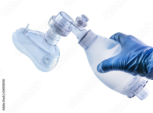 Hand holds resuscitator (ambu bag) with face mask