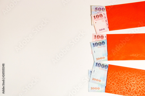 Red envelope packet with Taiwan money on white background for Chinese New Year. Translation: Good luck in the year.
