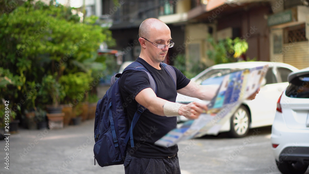 Caucasian Tourist in Bangkok Looking At Paper Map in Old Town Caucasian Tourist in Bangkok Looking At Paper Map in Old Town