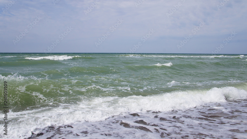 Summer day sea turquoise waves hit the shore. Sandy coast of the ocean.