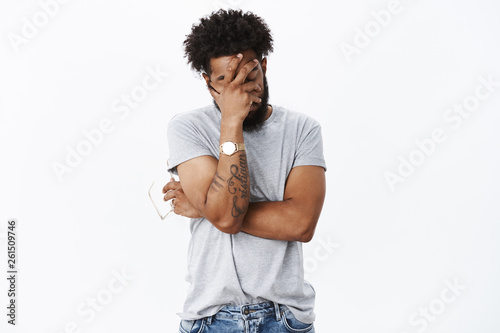 African american guy sick and tired actor making mistake during rehearsal making facepalm gesture from irritation and annoyance standing drained and uneasy with closed eyes over gray background photo