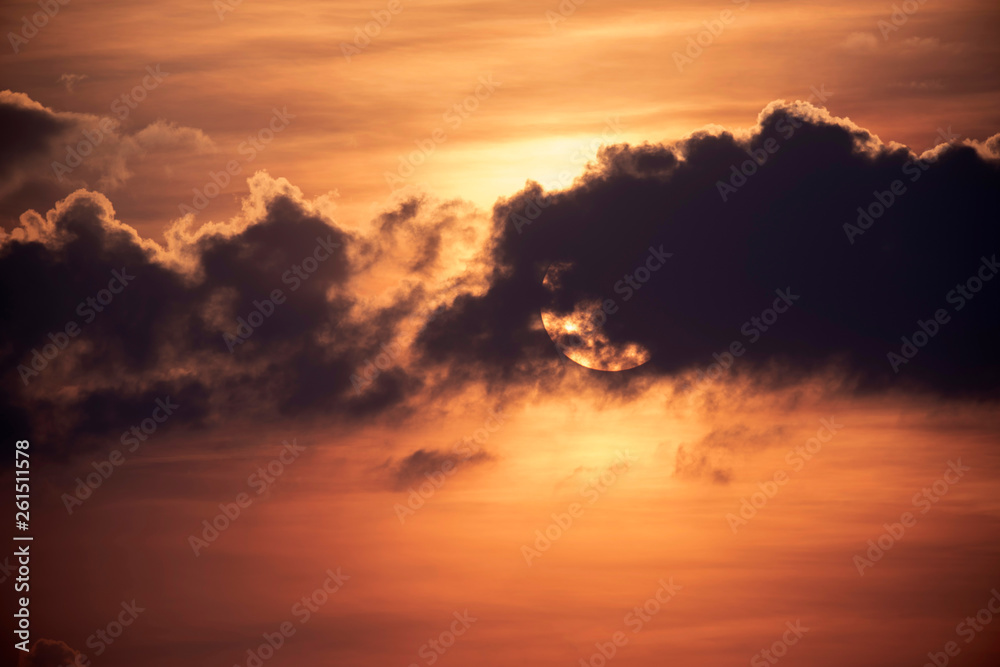 Cloudy sunset with sun behind cloud.