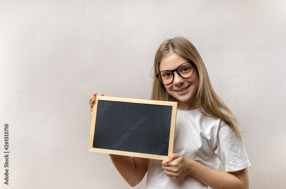 Beautiful mischievous girl with glasses holding a sign in her hands. copy-space Beautiful mischievous girl with glasses holding a sign in her hands. copy-space