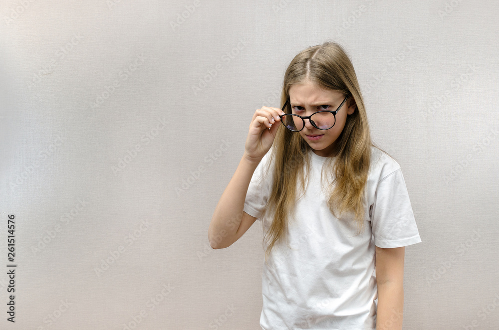 Cute girl with glasses look with a suspicious look. Doubt, mistrust, surprise Cute girl with glasses look with a suspicious look. Doubt, mistrust, surprise