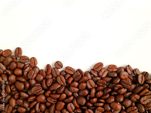 Top View of heap of roasted coffee beans on white background with free space for text and design