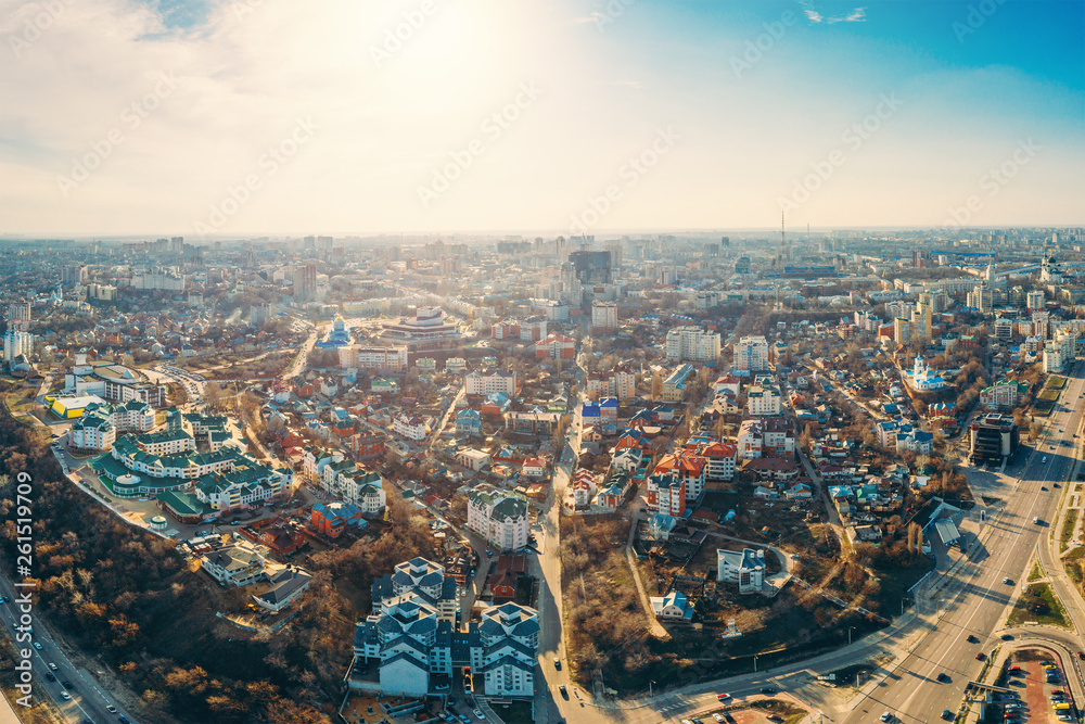Aerial panorama of city from above, high angle view to urban buildings, roads with cars, skyline in sunny spring day, drone shot