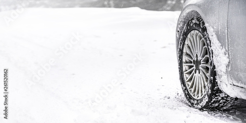 Detail of car winter tire - snow covered road, wide banner, empty space for text left. all logos brands on tyre removed photo