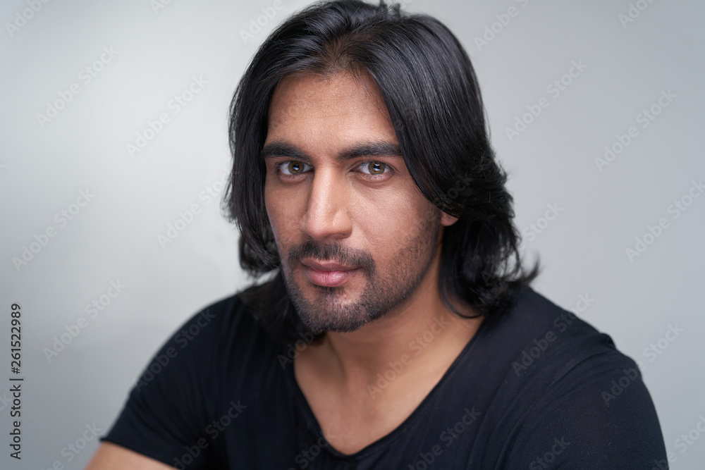 Portrait of Indian man with long black hair in studio Portrait of Indian man with long black hair in studio