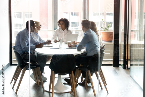 Multiracial business team people talking sitting at office boardroom table