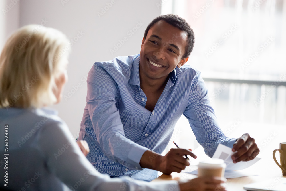 Smiling african american manager talking with client at business meeting - obrazy, fototapety, plakaty 