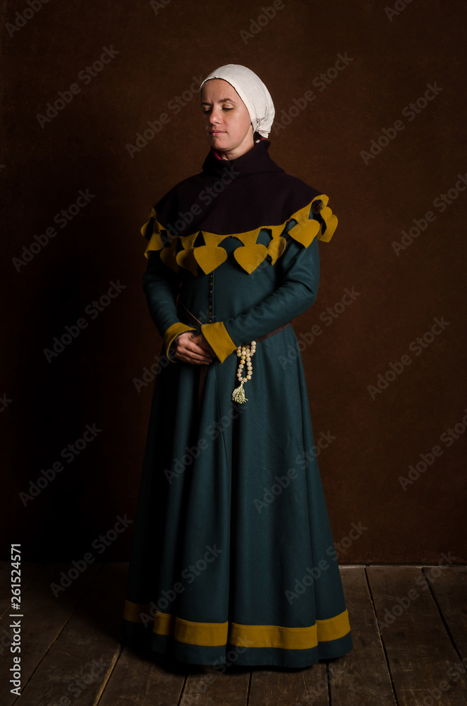 Beautiful modest girl in a medieval dress with a hood