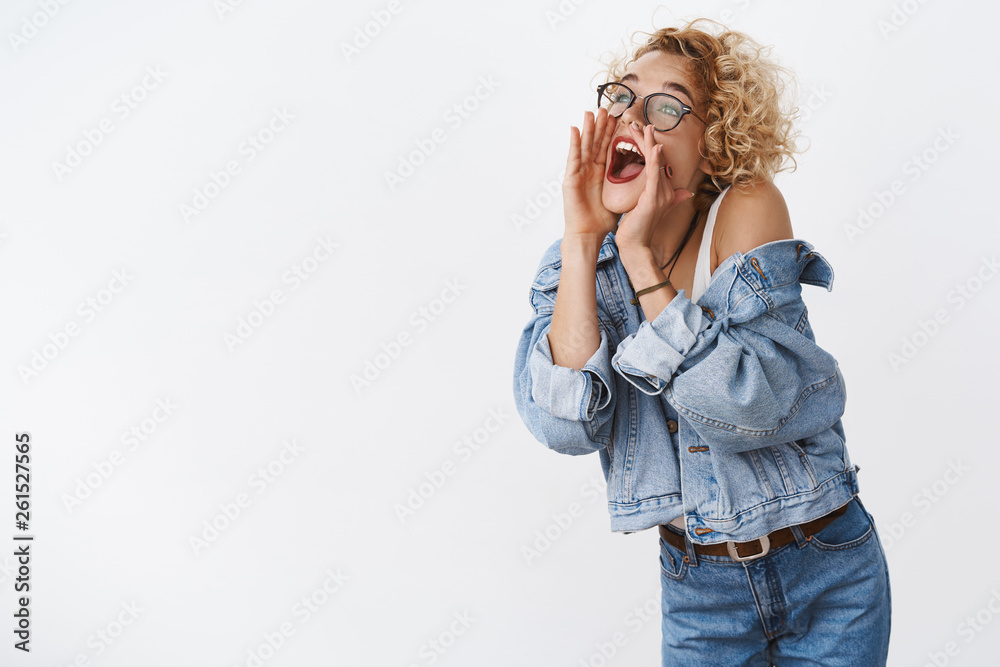 Girl turning left and yelling as calling for friend on distance holding hands near opened mouth to make voice louder standing amused and carefree over white background shouting searching someone Girl turning left and yelling as calling for friend on distance holding hands near opened mouth to make voice louder standing amused and carefree over white background shouting searching someone