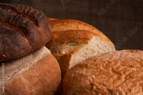 Different bread and wheat on the rustic table. Selective focus, close up