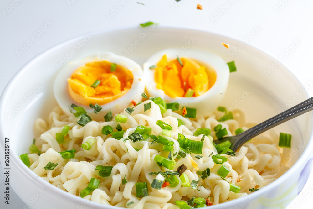 Instant noodles with vegetables and egg in plate. Noodles bowl on white background