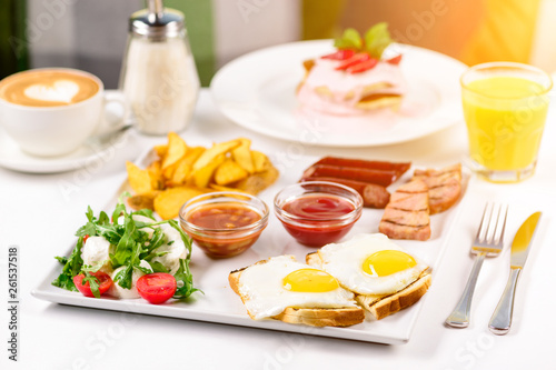Huge healthy breakfast spread on a table with coffee, orange juice, fruit, muesli, smoked salmon, egg