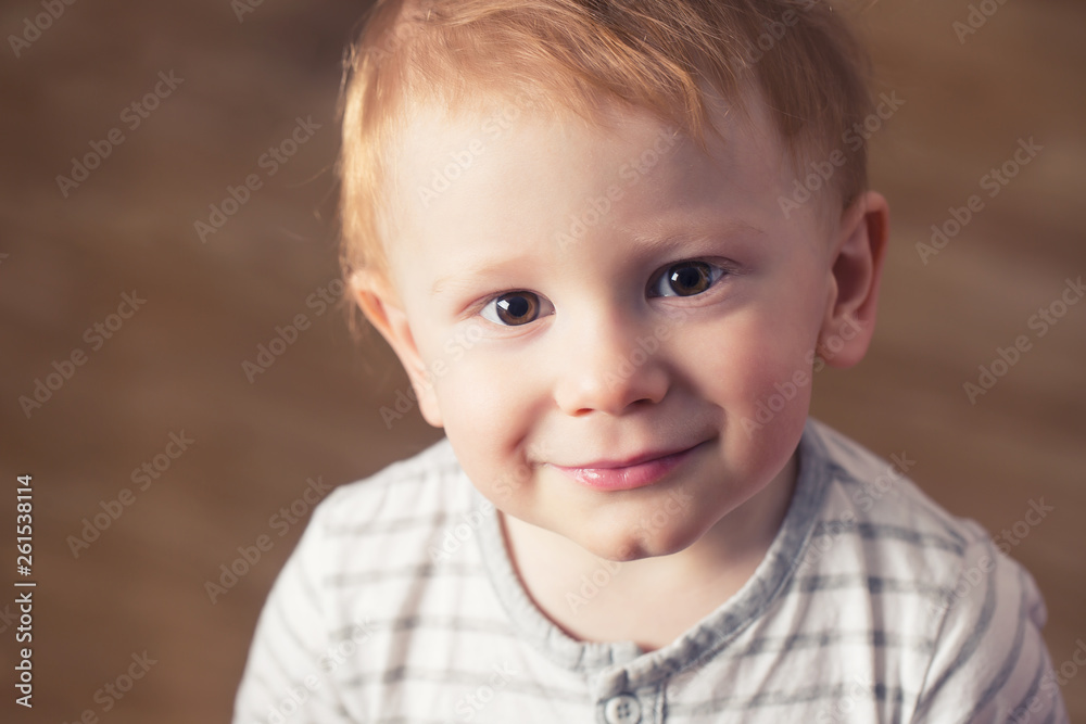 Portrait of little boy with nice smile looks into camera