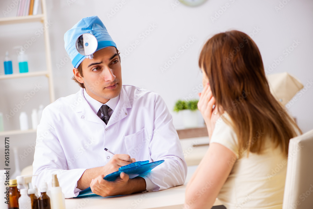Obraz premium Young woman visting male doctor otolaryngologist