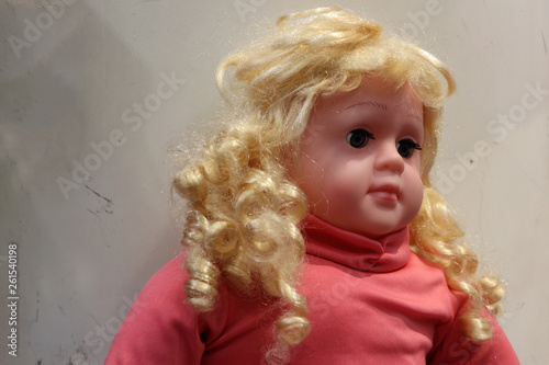 Girl doll with golden hair  wearing a red shirt.