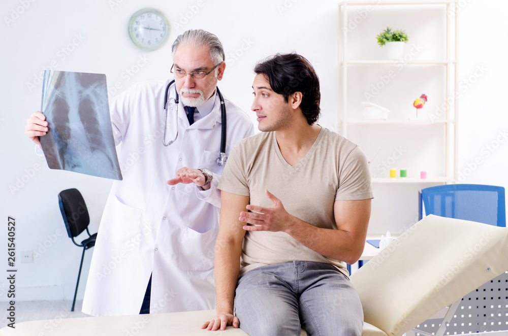 Young man visiting old male doctor radiologist Young man visiting old male doctor radiologist