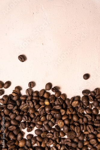 Roasted coffee beans in bulk on a light pink background. dark cofee roasted grain flavor aroma cafe, natural coffe shop background, top view from above, copy space