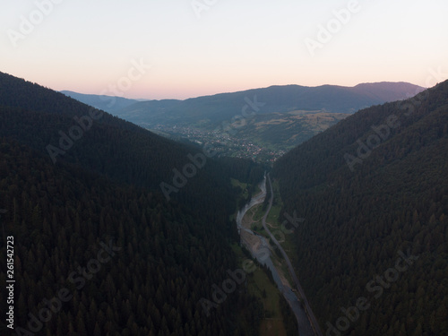 aerial view of sunset over mountains with forest and river