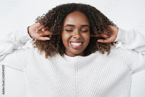 Girl refuse listen close earholes with index fingers and feeling happy, upbeat with shut eyes, smiling broadly and carefree enjoying silence posing delighted and amused over white background photo