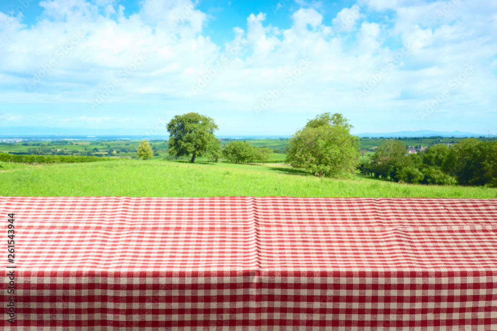 Empty table with tablecloth over summer meadow background Empty table with tablecloth over summer meadow background