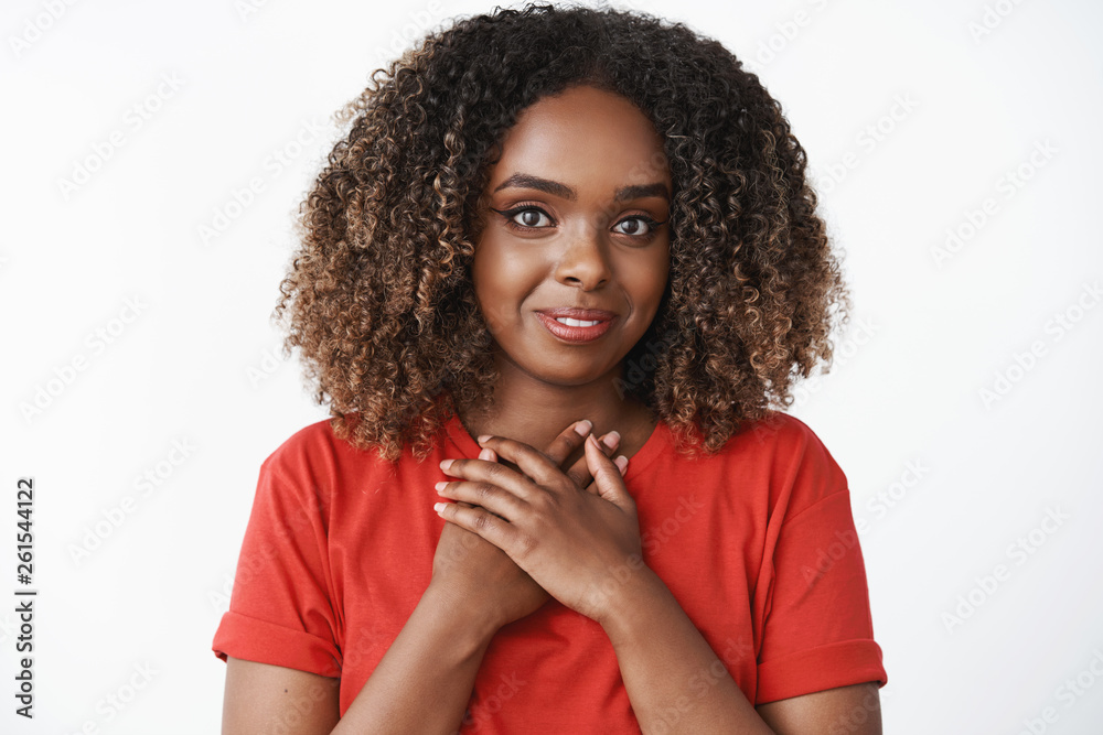Girl feeling grateful for sweet and generous gift holding palms together pressed to chest smiling sincere and lovely with caring loving gaze, being thankful for everything over white background Girl feeling grateful for sweet and generous gift holding palms together pressed to chest smiling sincere and lovely with caring loving gaze, being thankful for everything over white background