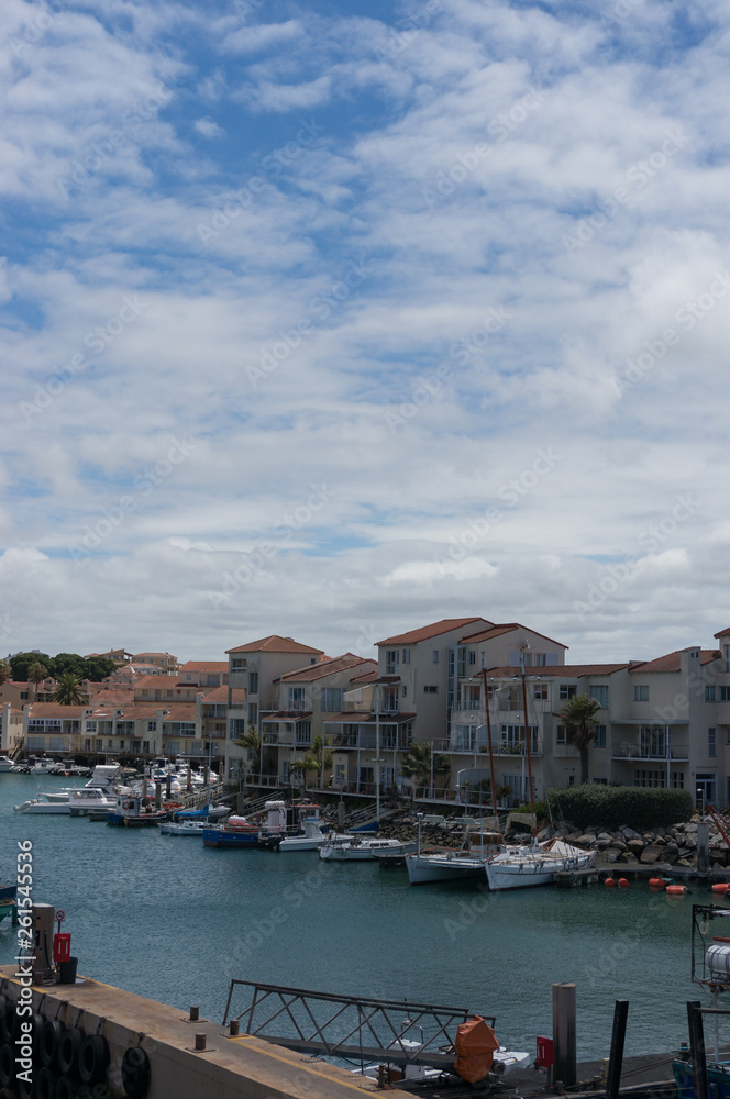 Boats and yachts at harbour with residential houses at waterfront