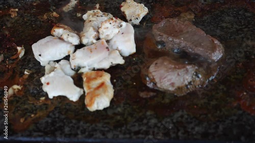 Meat cooking on hot stone grill