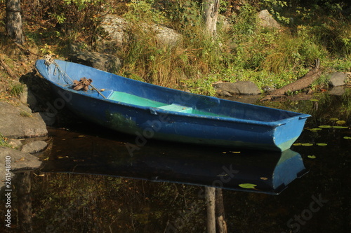 old blue boat pella on the rocky shore