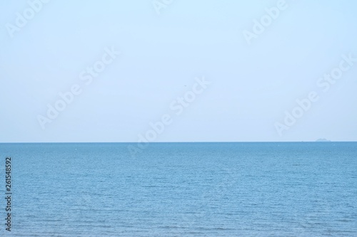 Blurred deep blue sea with water waves and blue sky in bright day for background backdrop 