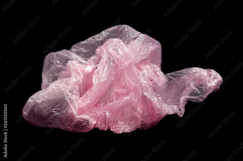 Pink plastic bag with handles on a black background isolate. Pink plastic bag with handles on a black background isolate.
