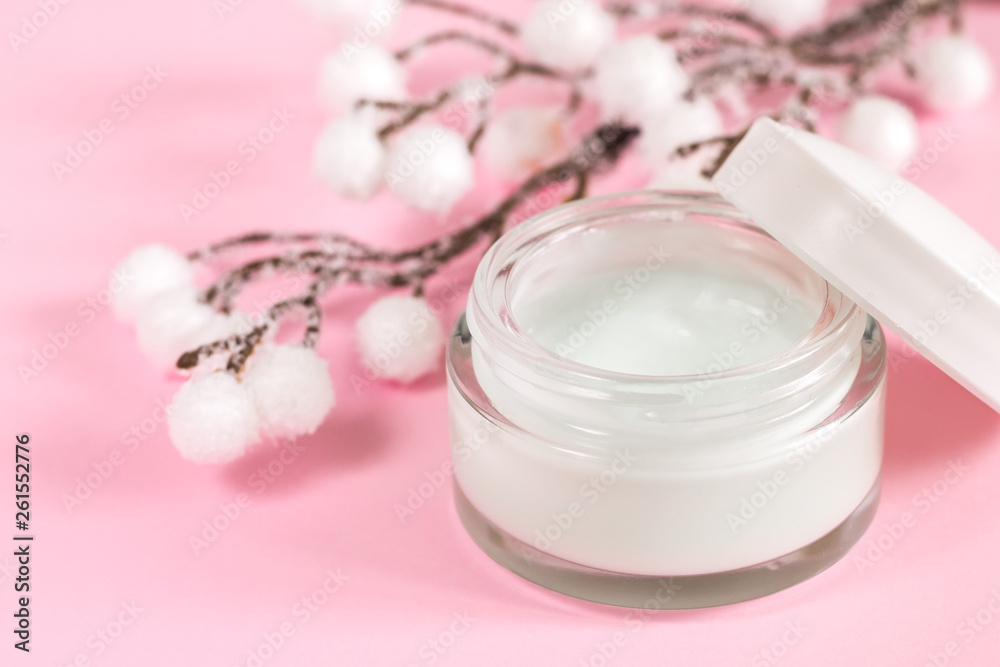 Cosmetic cream container on pink background with flowers. Face cream. Hand and face care. Day cream Cosmetic cream container on pink background with flowers. Face cream. Hand and face care. Day cream
