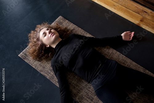 Canvas Print woman practicing in a yoga studio resting in shavasana or corps pose