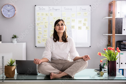 Businesswoman Meditating In Office photo