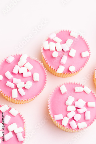 Colorful cupcakes on a pink background.