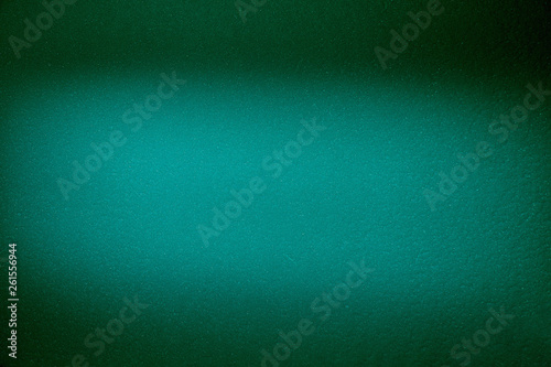 Blurred textural cloud of turquoise color on a dark green background