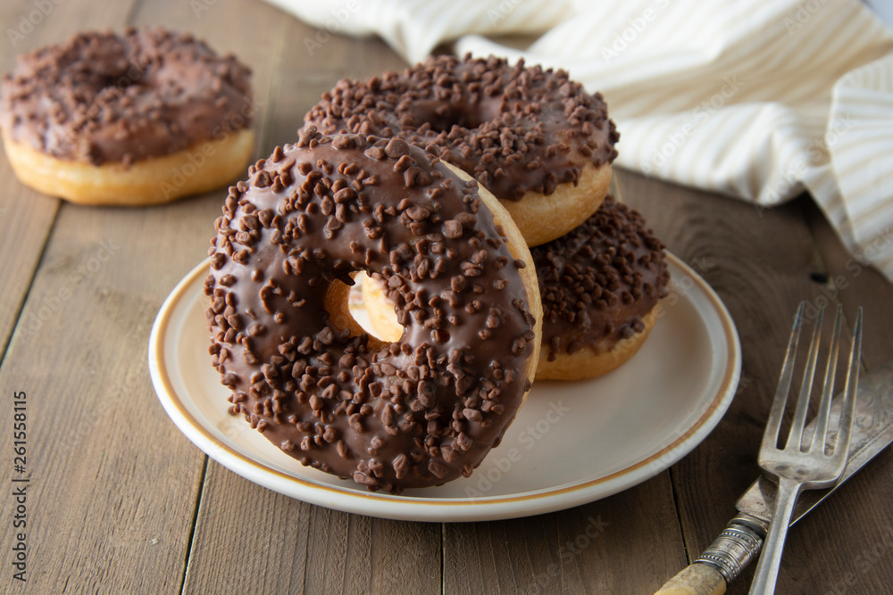 Chocolate donuts breakfast or dessert, wooden table. Close up glazed donuts. Sweet food. Pastry. Chocolate donuts breakfast or dessert, wooden table. Close up glazed donuts. Sweet food. Pastry.