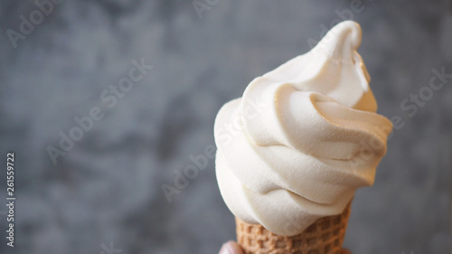 close up Soft serve ice cream cone in hand .